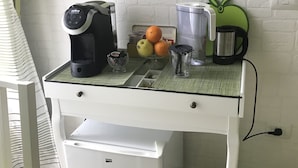 A compact kitchenette with a coffee maker, fruit bowl, and a small refrigerator. - Vatican City Holidays (Rome)