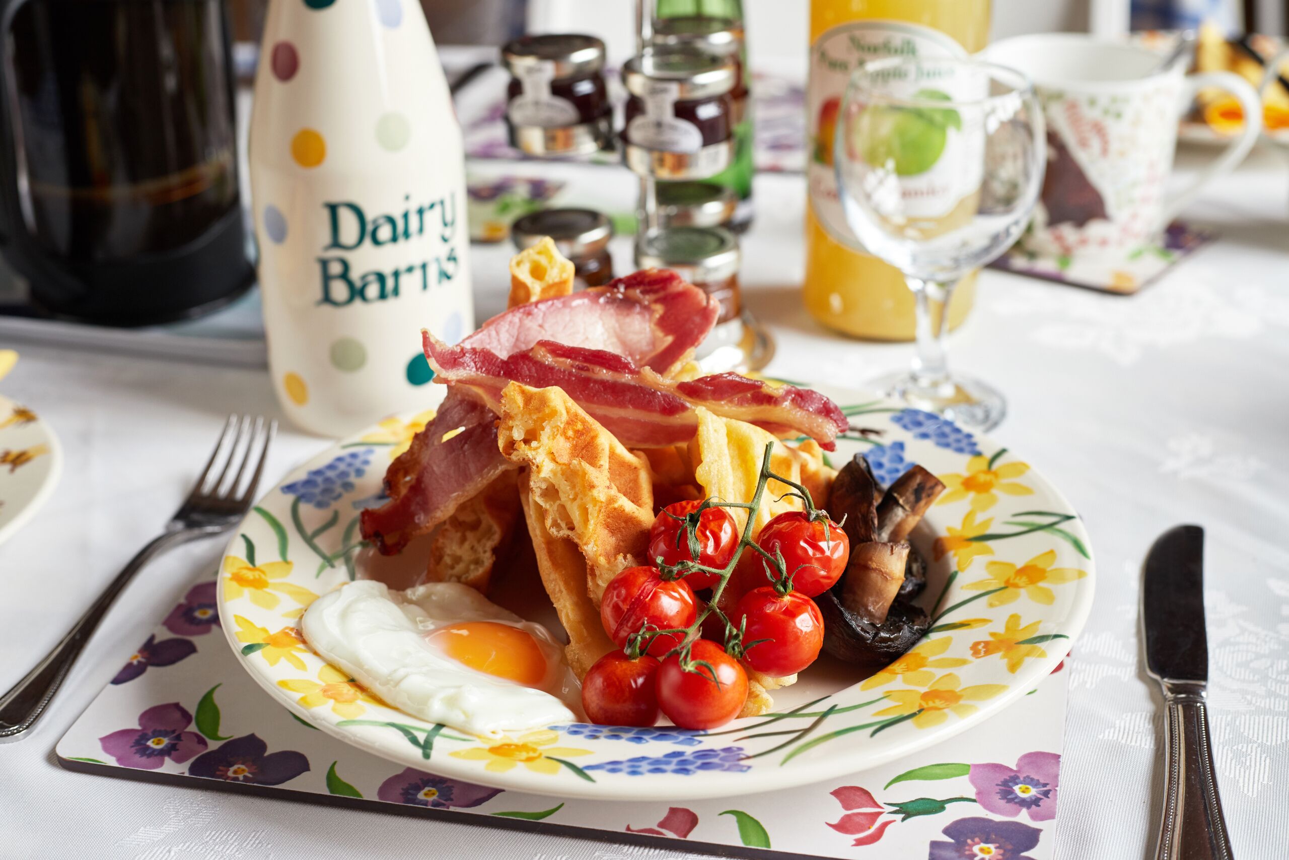Prato de café da manhã com ovos, bacon, cogumelos e tomates cereja.