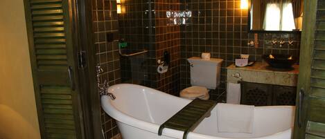 A bathroom with a freestanding bathtub, a toilet, and a sink.