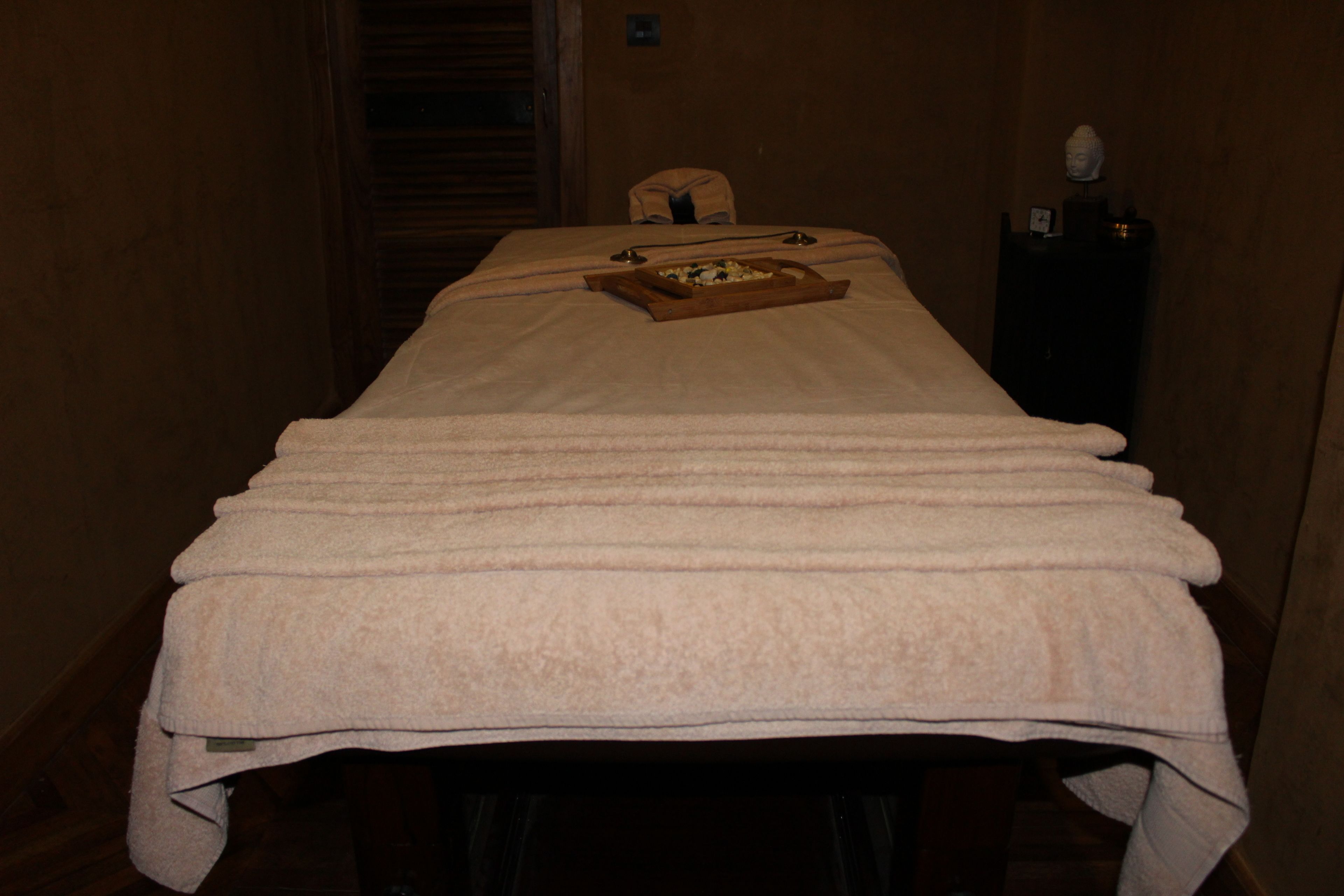 A massage table with towels and a tray of snacks.