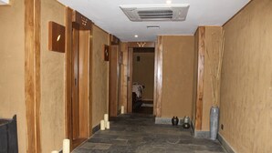 A hallway with wooden paneling, stone flooring, and a vent on the ceiling. - Druk Hotel (Thimphu)
