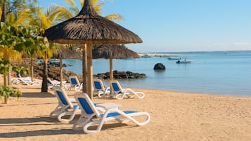 Una spiaggia nelle vicinanze, sabbia bianca, lettini da mare, ombrelloni