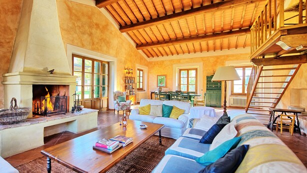 A spacious living room with a fireplace, a sofa set, a coffee table, and a staircase leading to an upper level. - Sabina (Manciano)