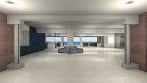 A spacious, modern lobby with a central circular seating area, large windows offering ocean views, and a minimalist design with neutral colors. - Hotel Ilyssion (Rhodes)