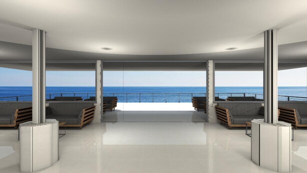 Un salón moderno y de planta abierta con vistas al mar, que cuenta con diferentes disposiciones de asientos y una barrera de cristal.