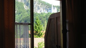 Una stanza con una grande finestra che si affaccia su una montagna e un castello.