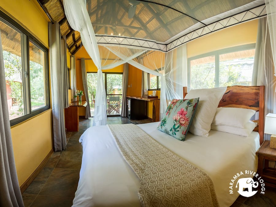 Un dormitorio con una cama grande, dosel y vistas al exterior.