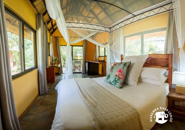 Un dormitorio con una cama grande, dosel y vistas al exterior.