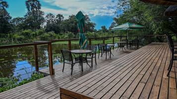 A wooden deck with outdoor seating and a view of a lake.