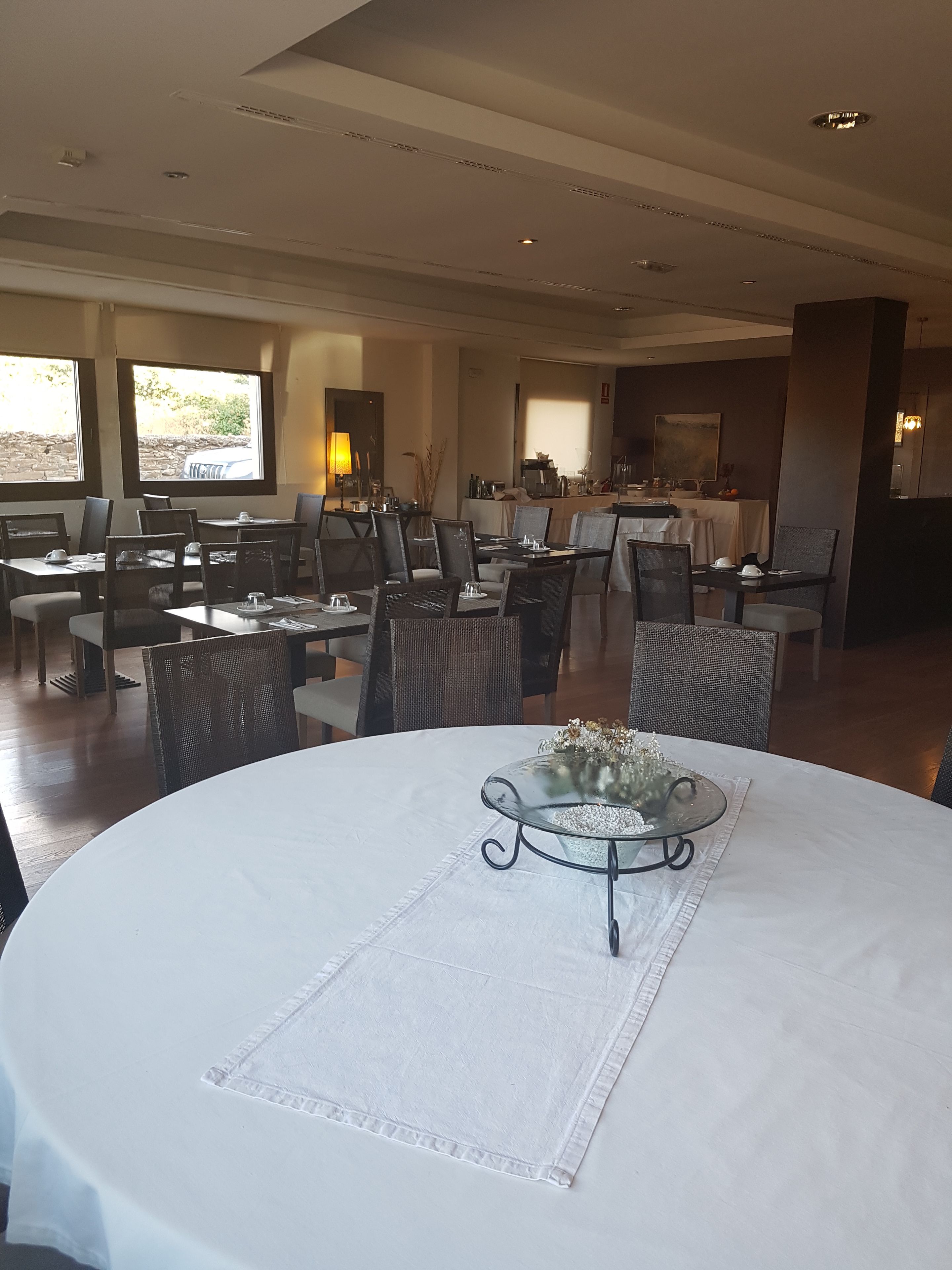 A dining area with round tables, chairs, and a central decorative table.