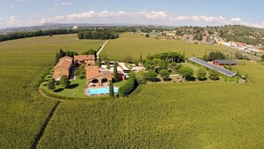 An aerial view of a property with a swimming pool, multiple buildings, and surrounding fields. - Country House Le Case Coloniche (Deruta)