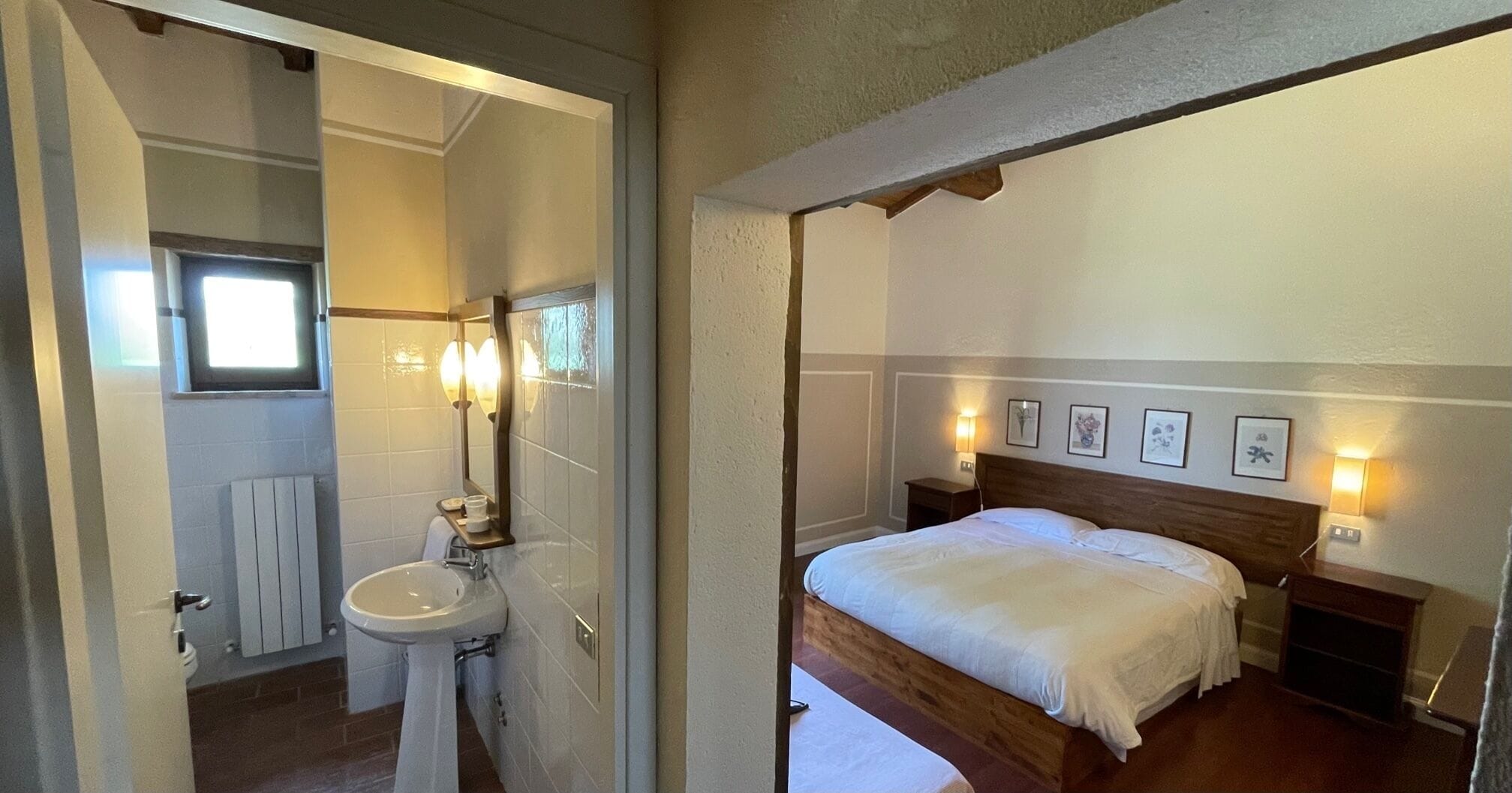 Un dormitorio con cama de madera, mesitas de noche y cuadros enmarcados en la pared.