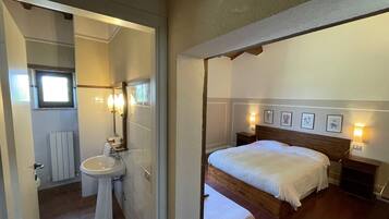 Una camera da letto con un letto di legno, comodini e quadri appesi alle pareti.