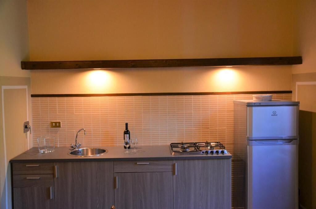 A compact kitchen with a sink, gas stove, and a refrigerator.
