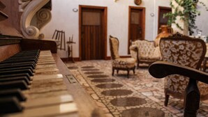 A piano in a room with patterned flooring and wooden furniture. - A Locanda Tù Marchese (Matino)