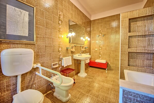 A bathroom with a toilet, bidet, sink, and bathtub. - Villa Lauretana (Torrita di Siena)