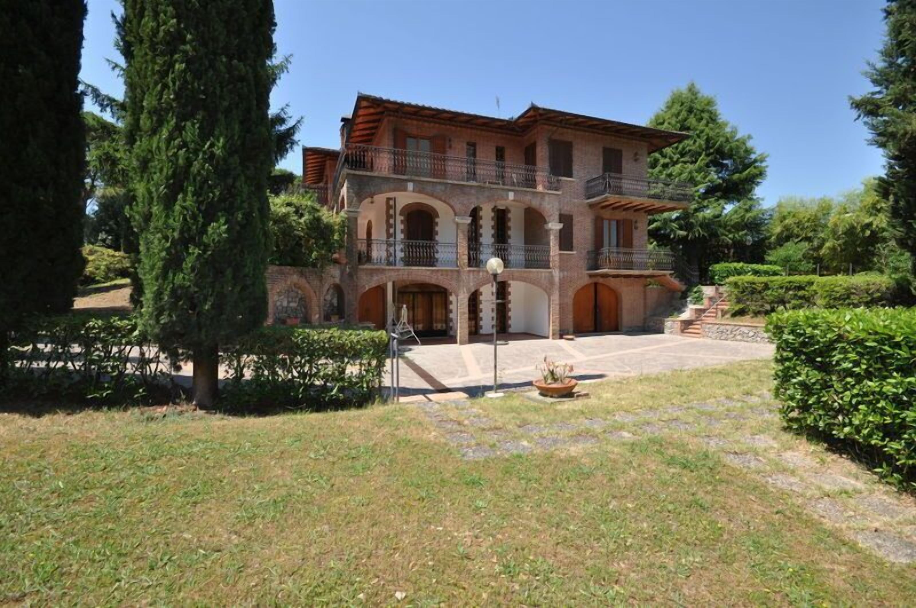 A two-story building with a central courtyard, arched doorways, and a balcony on the upper floor.