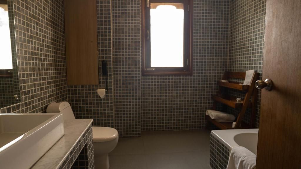 Un baño con bañera, inodoro y ventana.