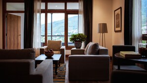 A modern living room with a sofa, armchairs, a coffee table, and a potted plant. - Hotel Osel (Thimphu)