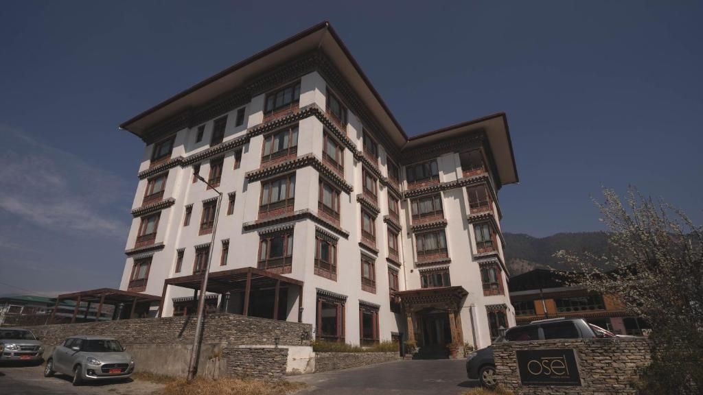 Un edificio de varios pisos con un estilo arquitectónico tradicional, que cuenta con balcones y fachada de piedra.