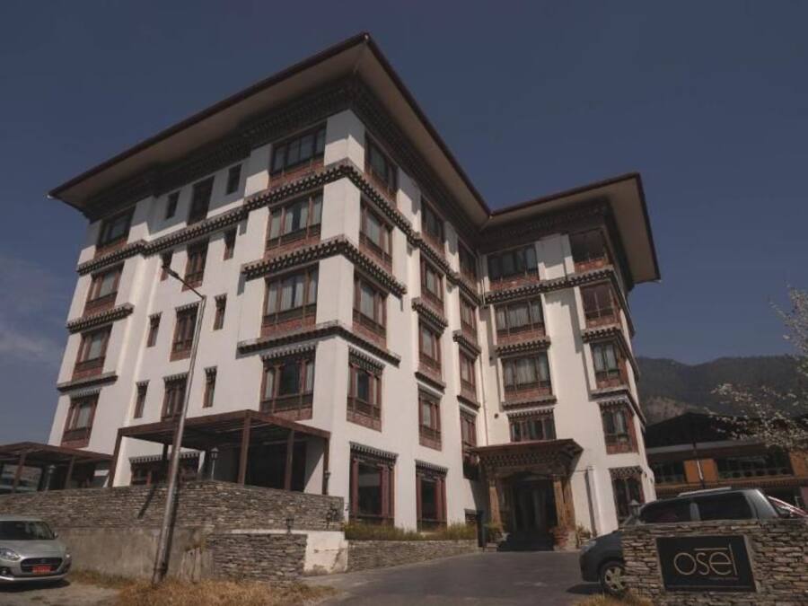 Un edificio de varios pisos con un estilo arquitectónico tradicional, que cuenta con balcones y fachada de piedra.