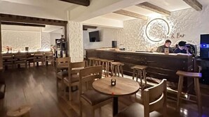 A cozy restaurant with wooden furniture and exposed beams. - Hotel Osel (Thimphu)