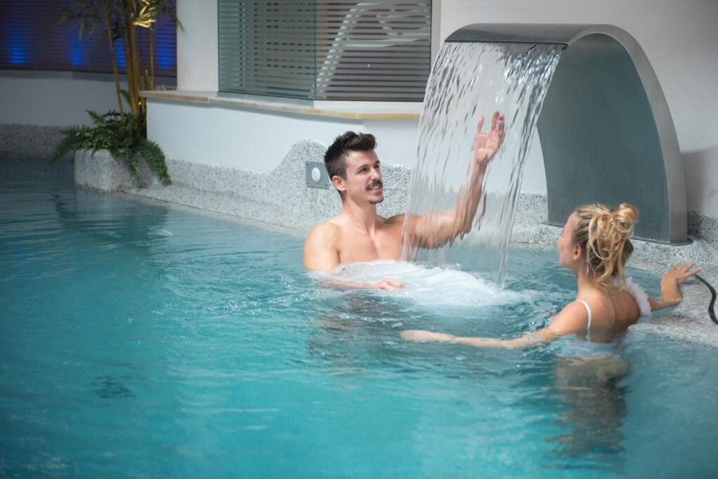 indoor pool, a waterfall pool, pool loungers