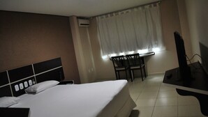 A hotel room with a bed, a desk, a chair, and a TV. - Pinheiro Palace Hotel (Rio Branco)