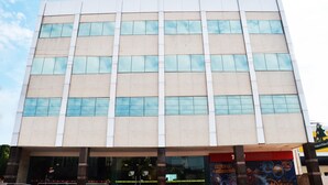 A modern building with a grid of windows and a storefront at the ground level. - Pinheiro Palace Hotel (Rio Branco)
