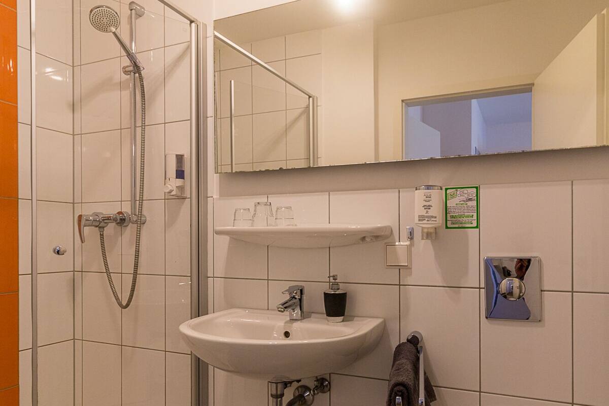 A bathroom with a shower, sink, and toilet.