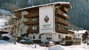 Een meerlaags gebouw met een bord waarop staat: GASTHOF Restaurant ECKARTAUERHOF.