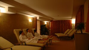 Een hotel lobby met rijen lounge fauteuils en enkele gasten.