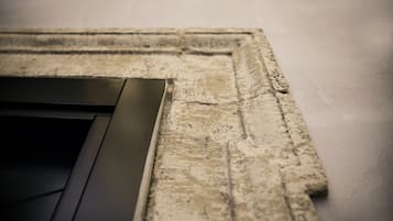 Primer plano de una pared texturizada con una puerta o panel de color oscuro.
