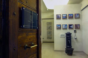 Una puerta de madera con una placa que dice "Prestige Rooms" y una pared con cuadros enmarcados.