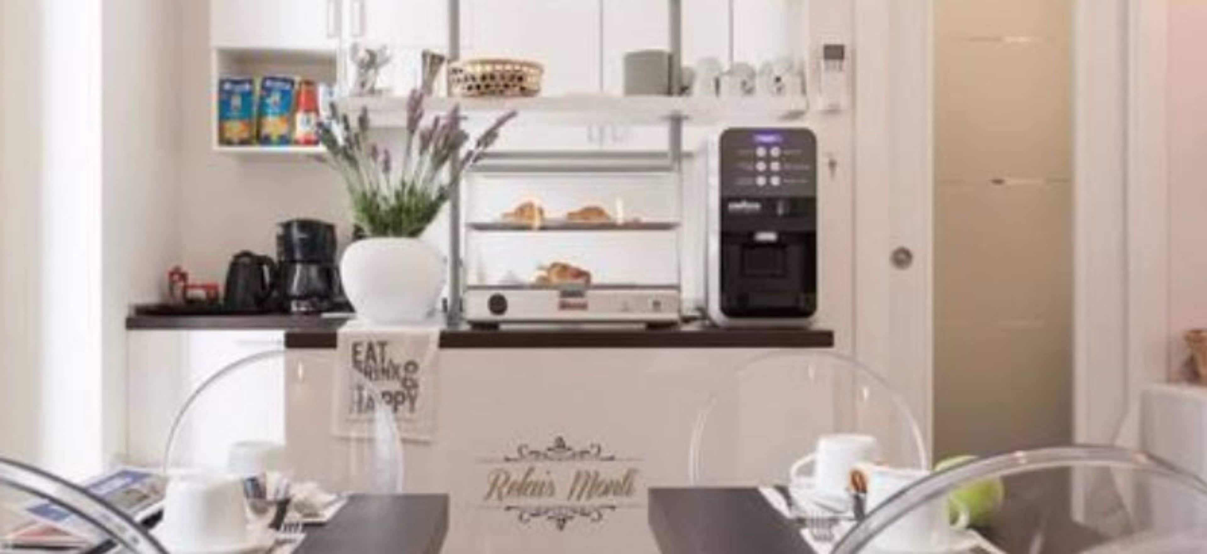 A modern kitchen with a coffee machine, a bread display, and a sign that reads "EAT, ENJOY, HAPPY".