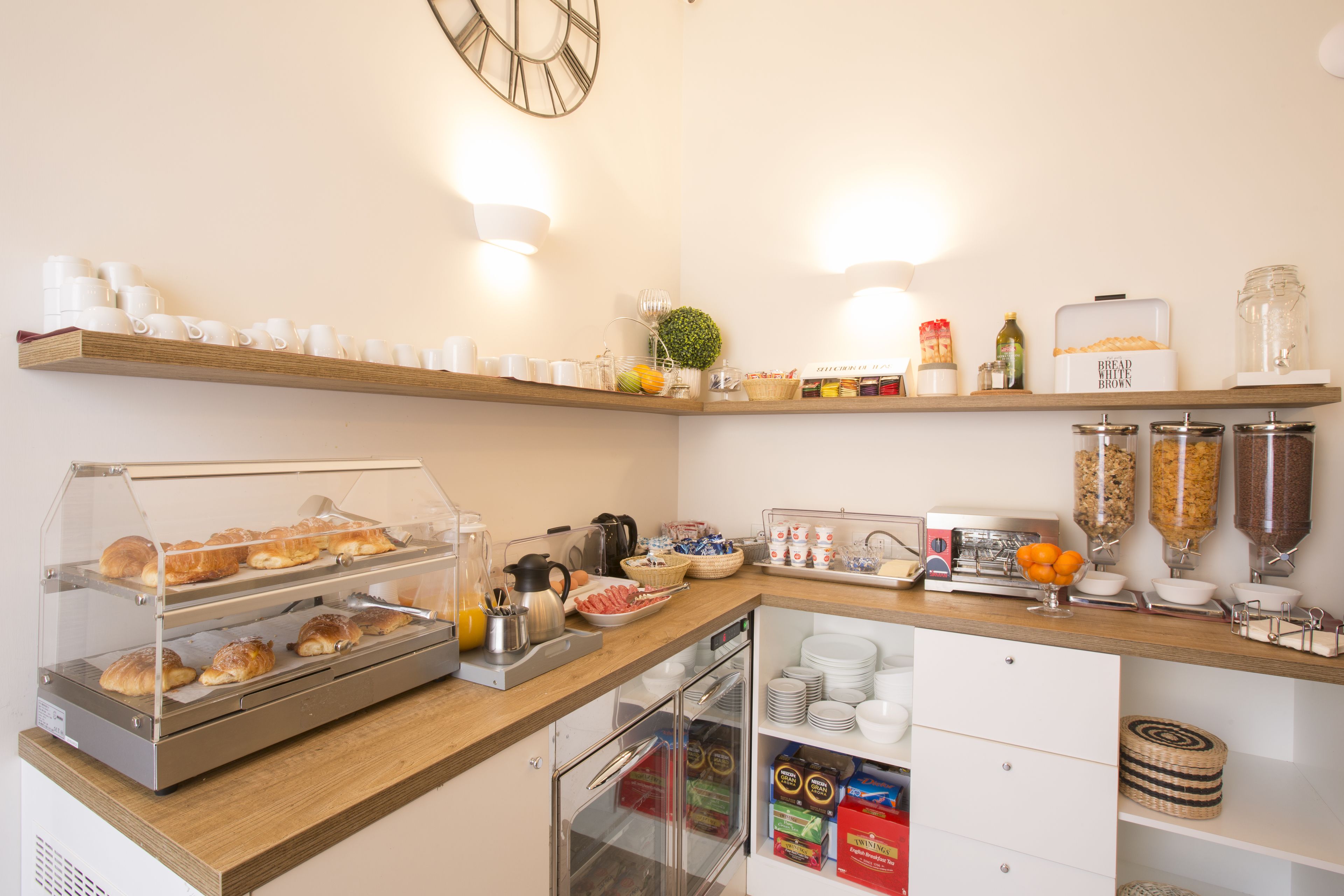 Un buffet de petit-déjeuner proposant des viennoiseries, des fruits et des boissons.