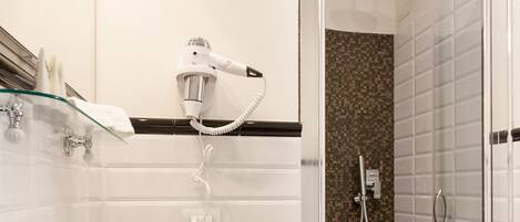 A modern bathroom with a large white sink, a glass shower enclosure, and a wooden vanity.