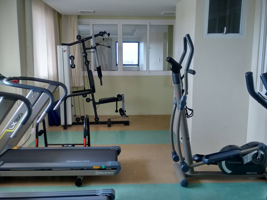 A fitness room with treadmills, elliptical machines, and a stationary bike.