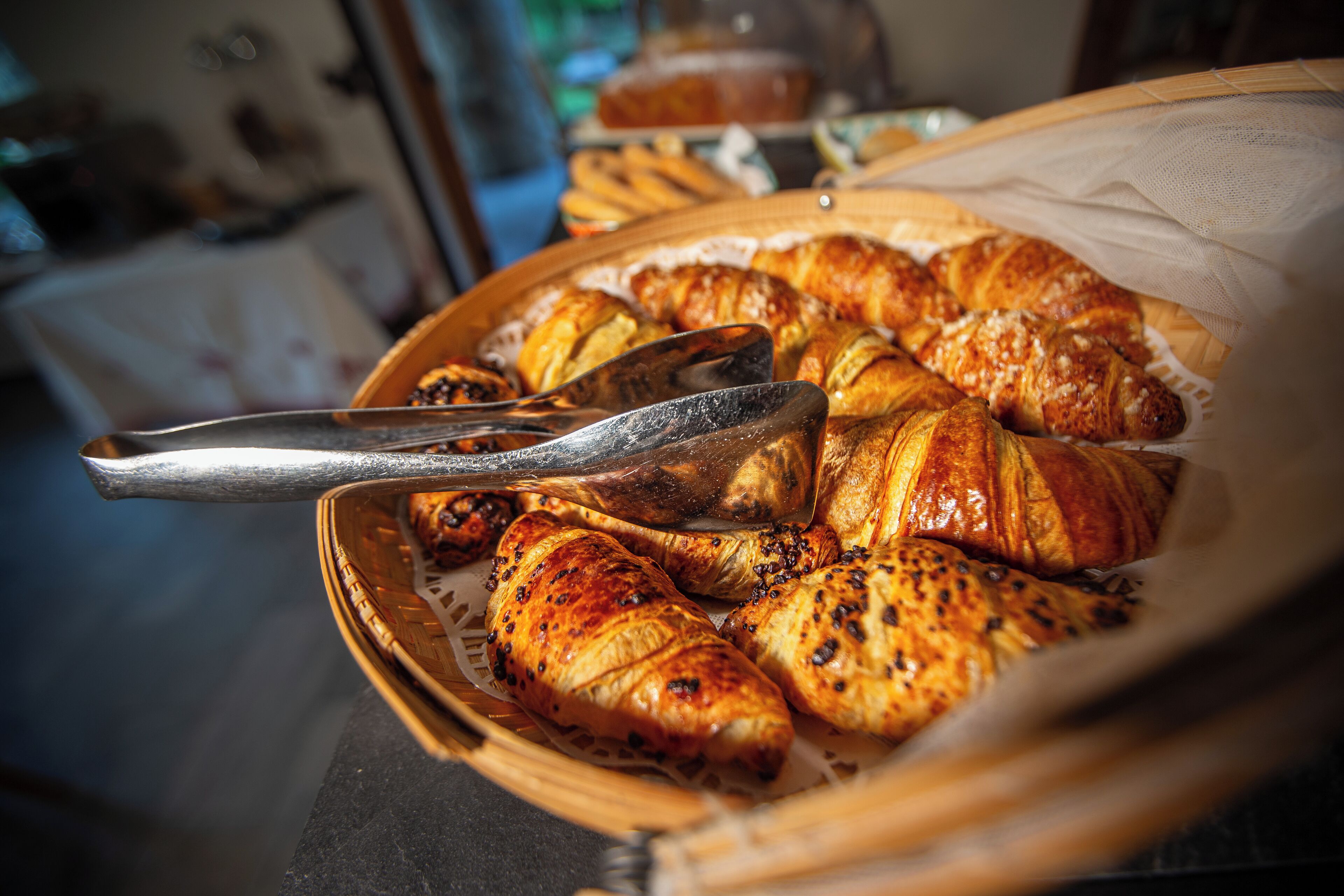 A basket of croissants and a pastry brush.