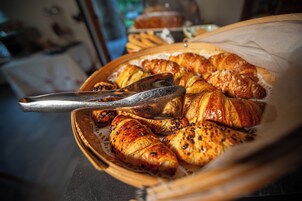 Una cesta con cruasanes y un pincel para pastelería.
