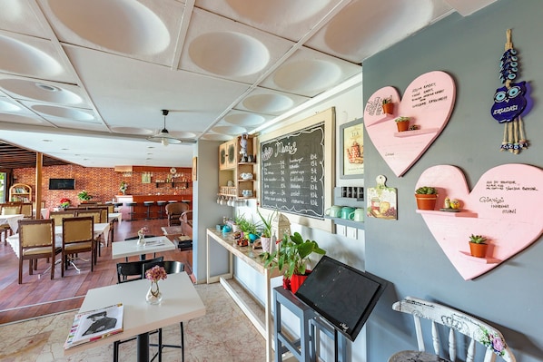 Ein Restaurant mit einer Kreidetafel, herzförmiger Dekoration und einer Backsteinwand.