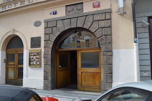 Hotel Medvedka features an arched entrance with a glass door and stone facade.