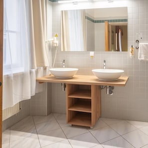 A bathroom with two sinks, a mirror, a towel rack, and a shower curtain.