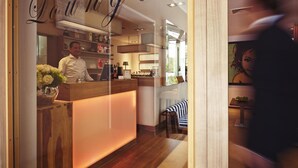 A reception area with a wooden counter, a man standing behind it, and a sign above reading "Lunge". - Hotel Bonjour (Bad Soden am Taunus)