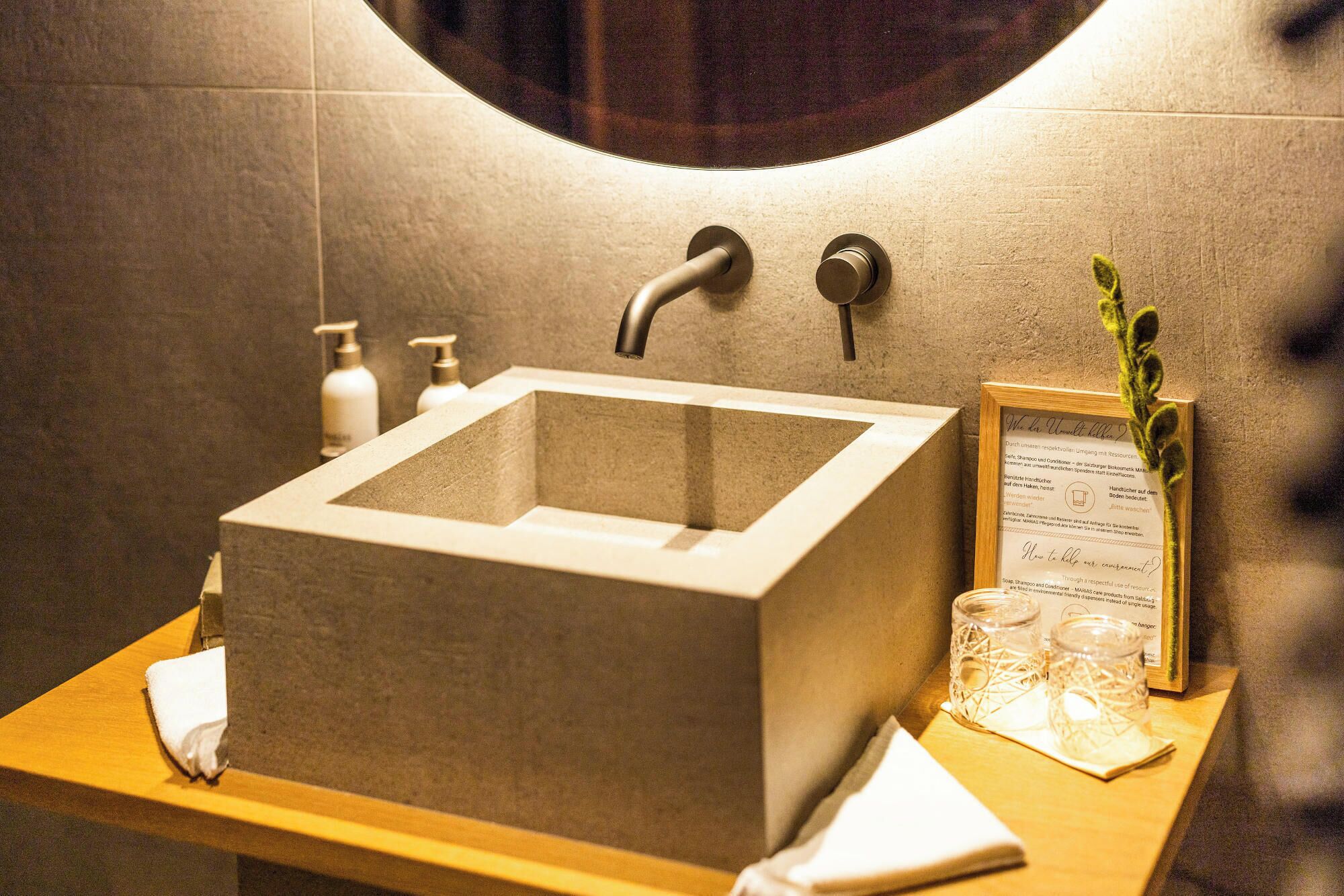 Ein Badezimmer mit einem modernen Waschbecken, einem Handtuch und einer informativen Karte im Bilderrahmen.