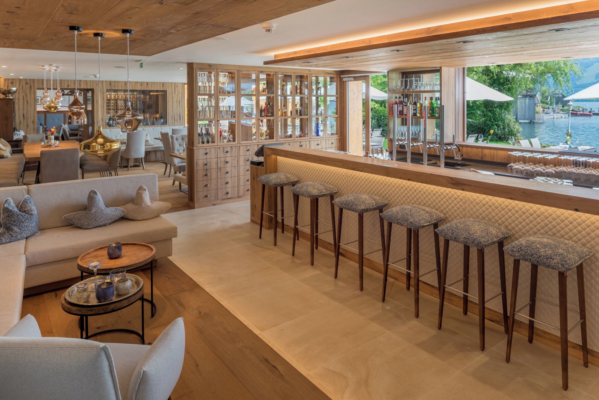 A bar area with stools and a view of the outdoors.