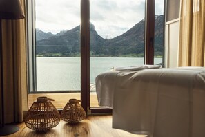 A room with a bed, large windows, and two wicker lamps. - Hotel Seevilla Wolfgangsee (Sankt Wolfgang im Salzkammergut)