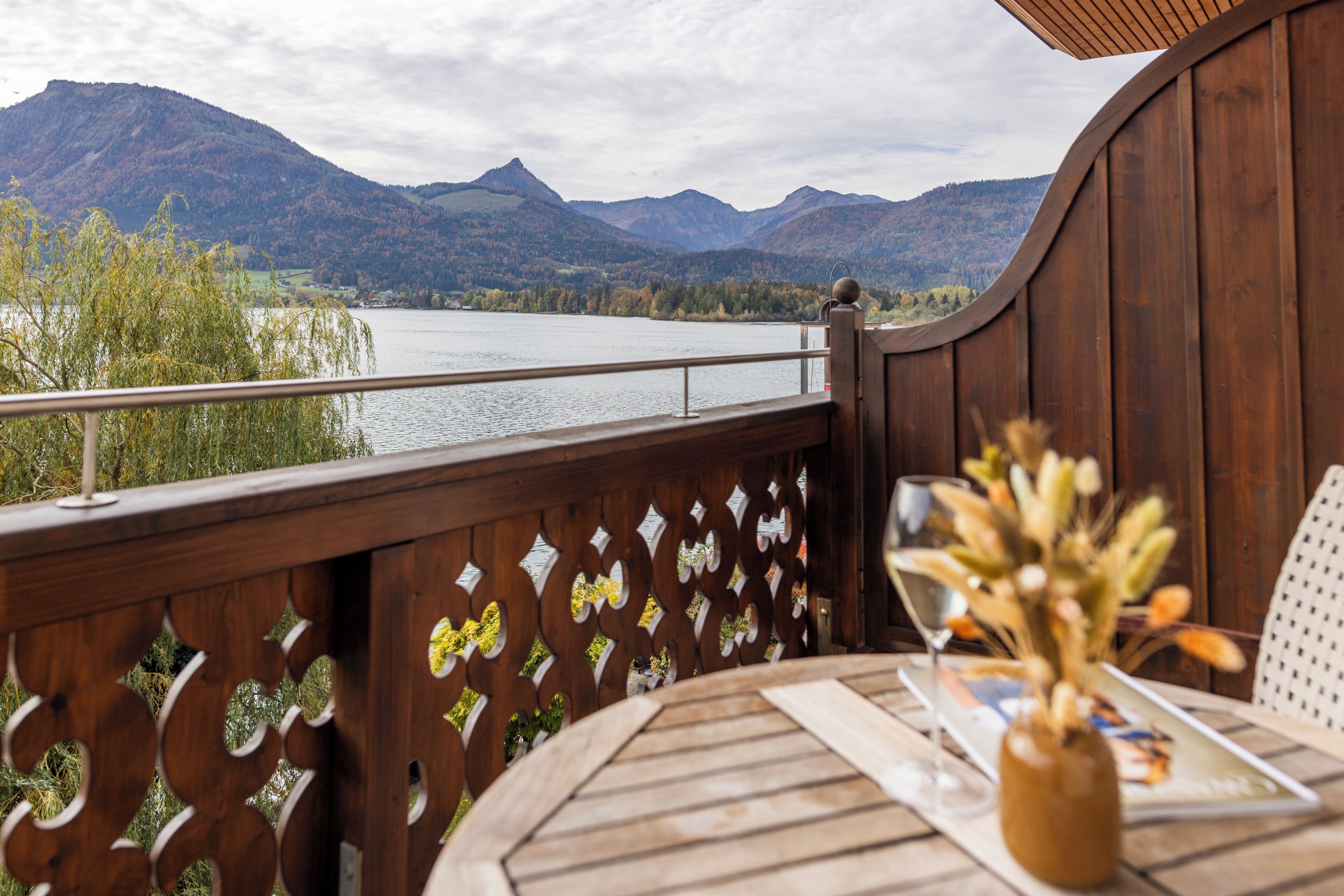 A wooden deck with a view of a lake and mountains.