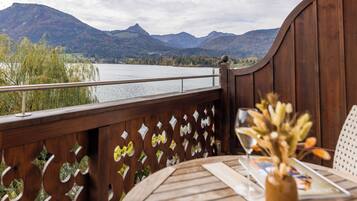 A wooden deck with a view of a lake and mountains.