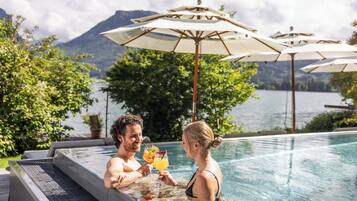 Een buitenzwembad, parasols voor strand/zwembad